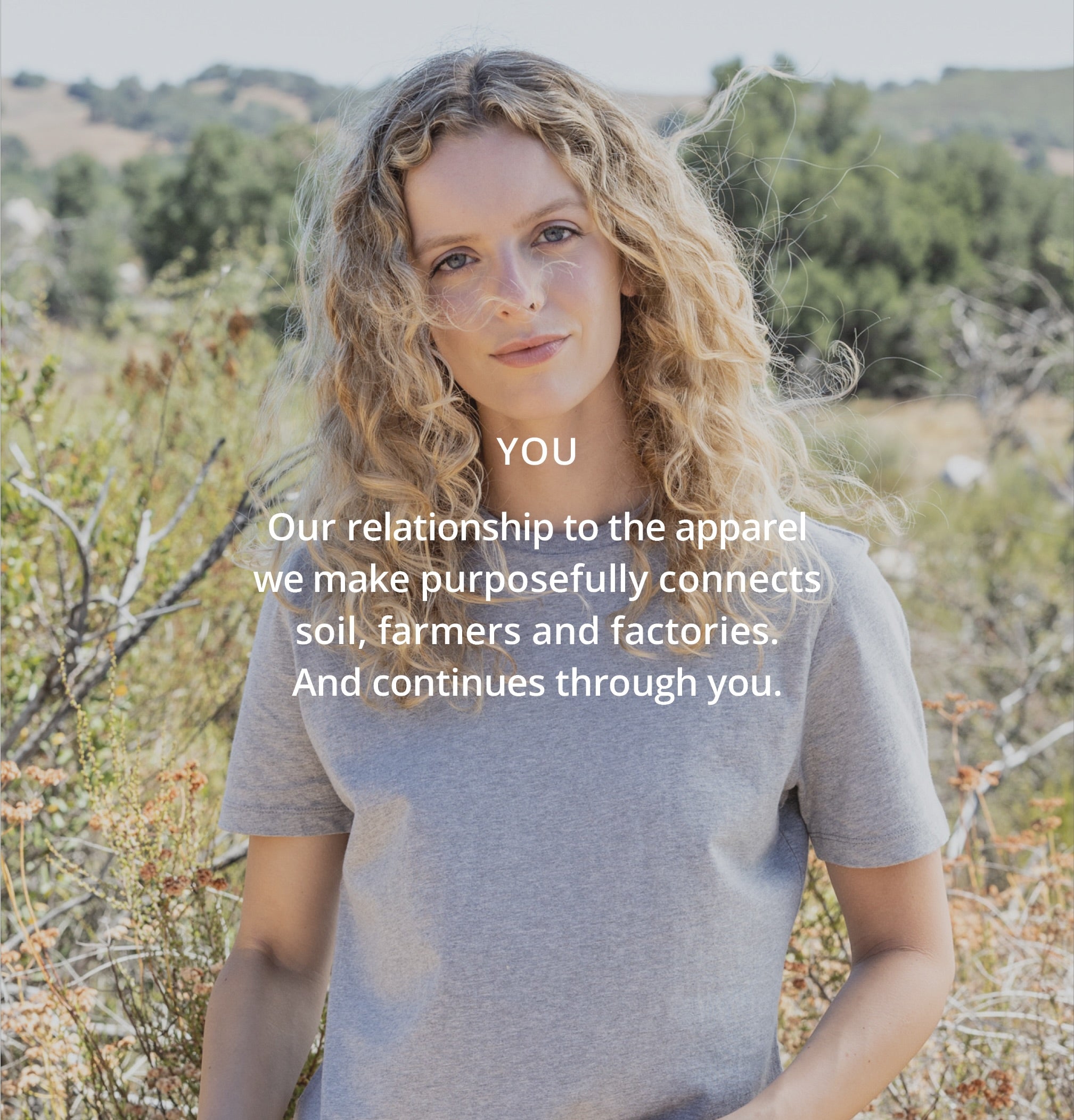 Woman standing outdoors with a message about the relationship between apparel and its impact on soil, farmers, and factories.