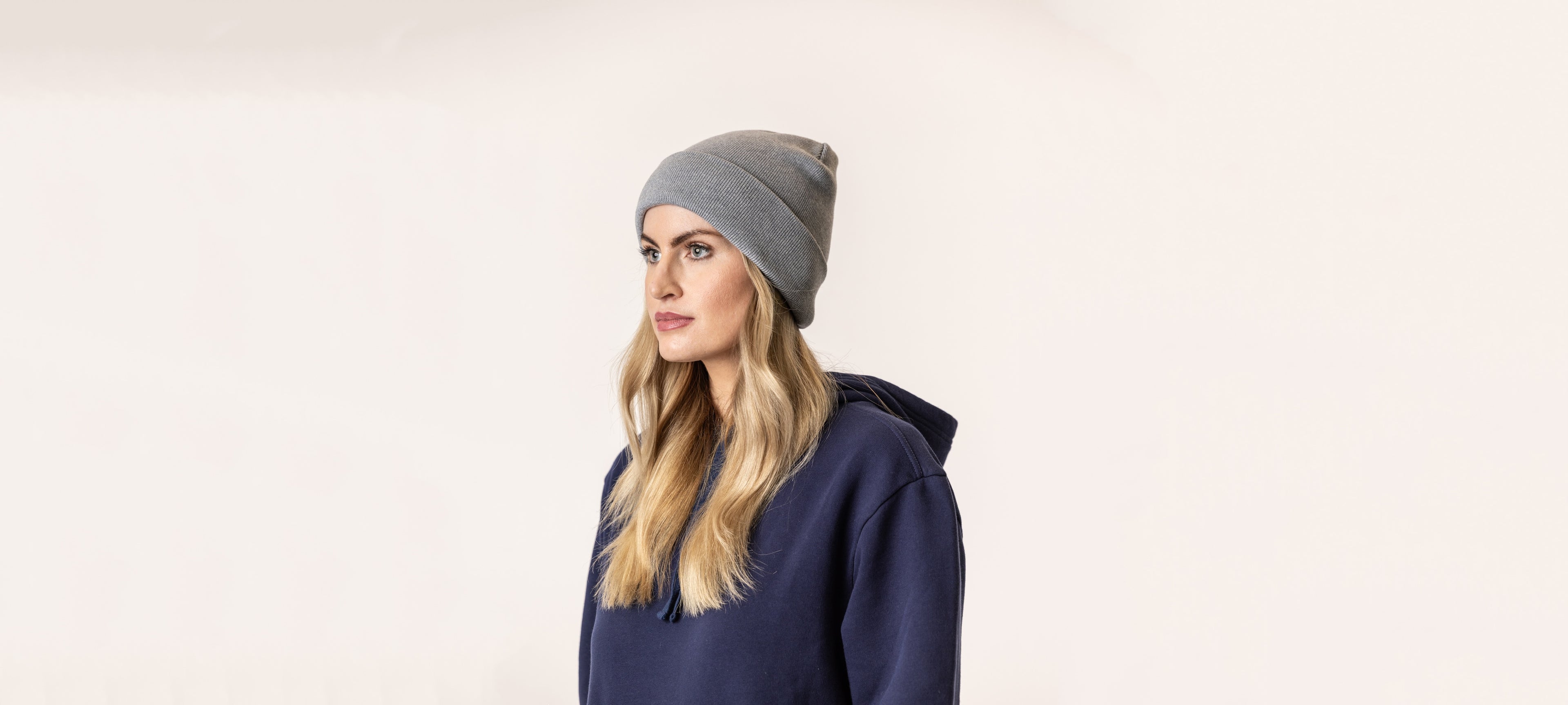 Woman wearing a gray beanie and navy hoodie